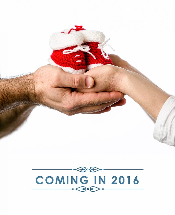 Mom and dad to be holding baby slippers in hands. pregnancy announcements